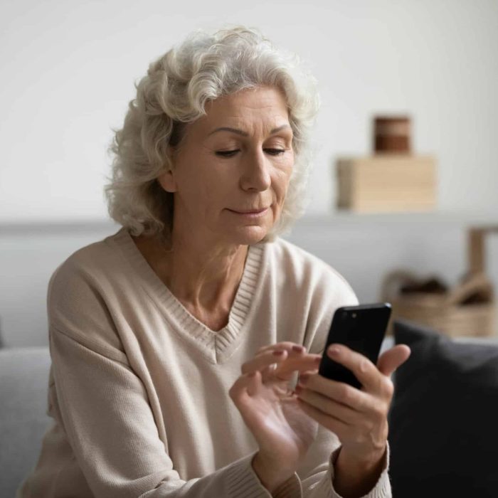 Personne âgée sur son téléphone faisant sa préadmission en ligne