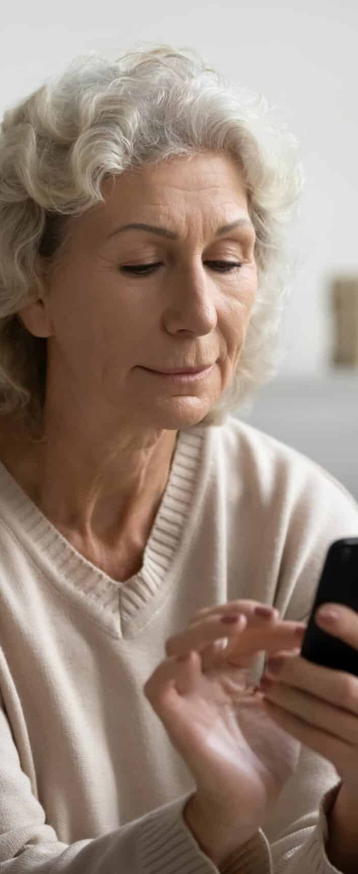 Personne âgée sur son téléphone faisant sa préadmission en ligne